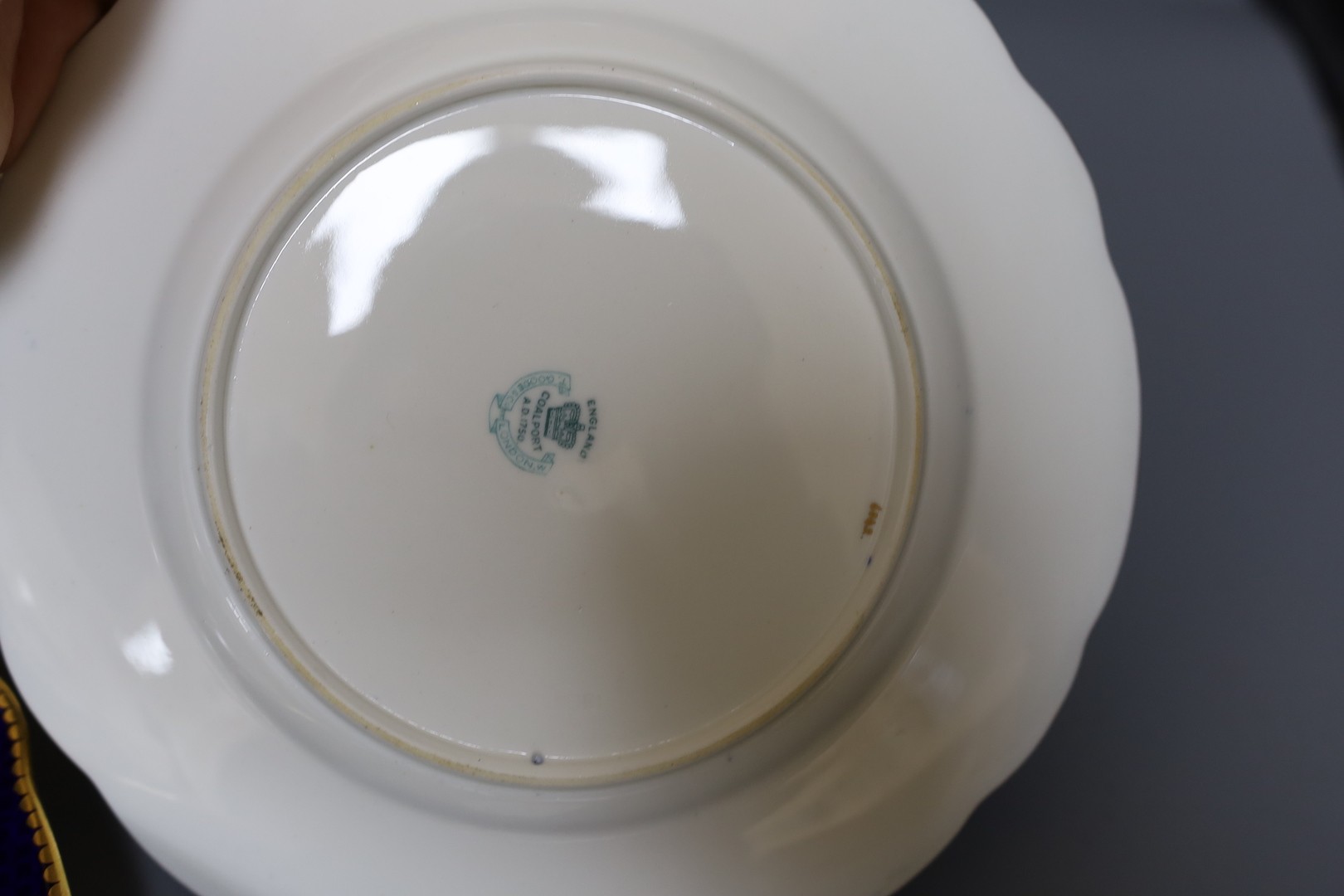 A Late 19th/early 20th century Coalport set of six plates and a square dish, which is signed F Howard, one plate signed P Simpson and four plates initialled PHS for Percy Simpson, Coalport crown England mark and T Goode